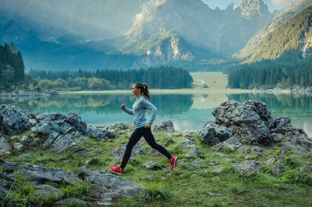 Junge Frau beim Laufen in Salzburg mit See-Panorama